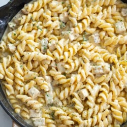 White Cheddar Chicken Pasta in a skillet with chopped parsley on top.